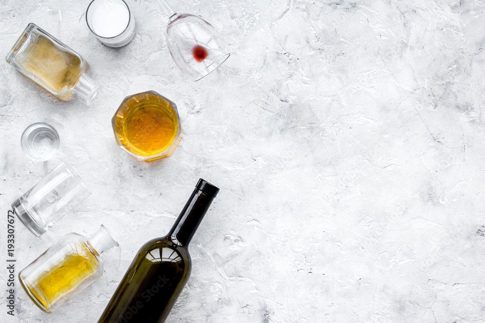 Alcohol abuse. Drunkennes. Glasses and bottles on grey background top view copy space Alcohol abuse. Drunkennes. Glasses and bottles on grey background top view copy space