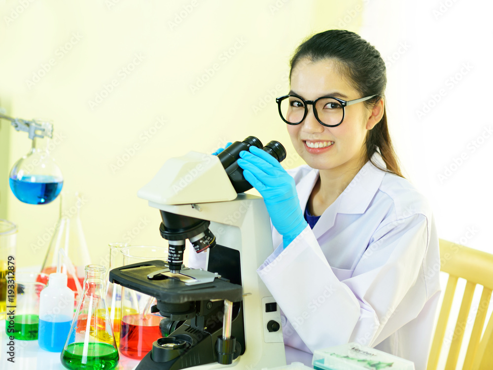 Fototapeta premium Asian female medical technologist working with microscope 