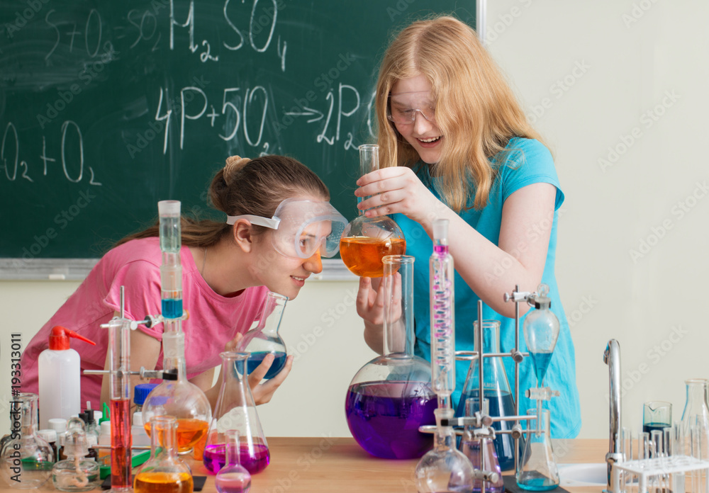 two girls doing chemical experiments two girls doing chemical experiments