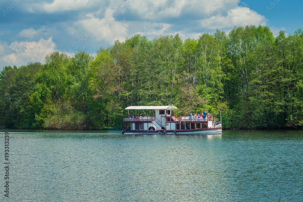 Tourist steamer on a river in the background of forest and green trees, concept of leisure, tourism and lifestyle with copy space Tourist steamer on a river in the background of forest and green trees, concept of leisure, tourism and lifestyle with copy space