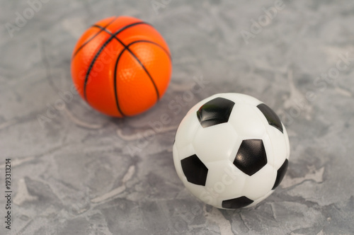 Two new soft rubber soccer and basketball balls on old worn cement