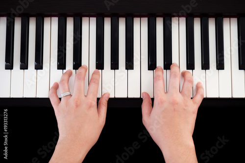 Woman playing piano. Top view with black isolate background. Art and music background.