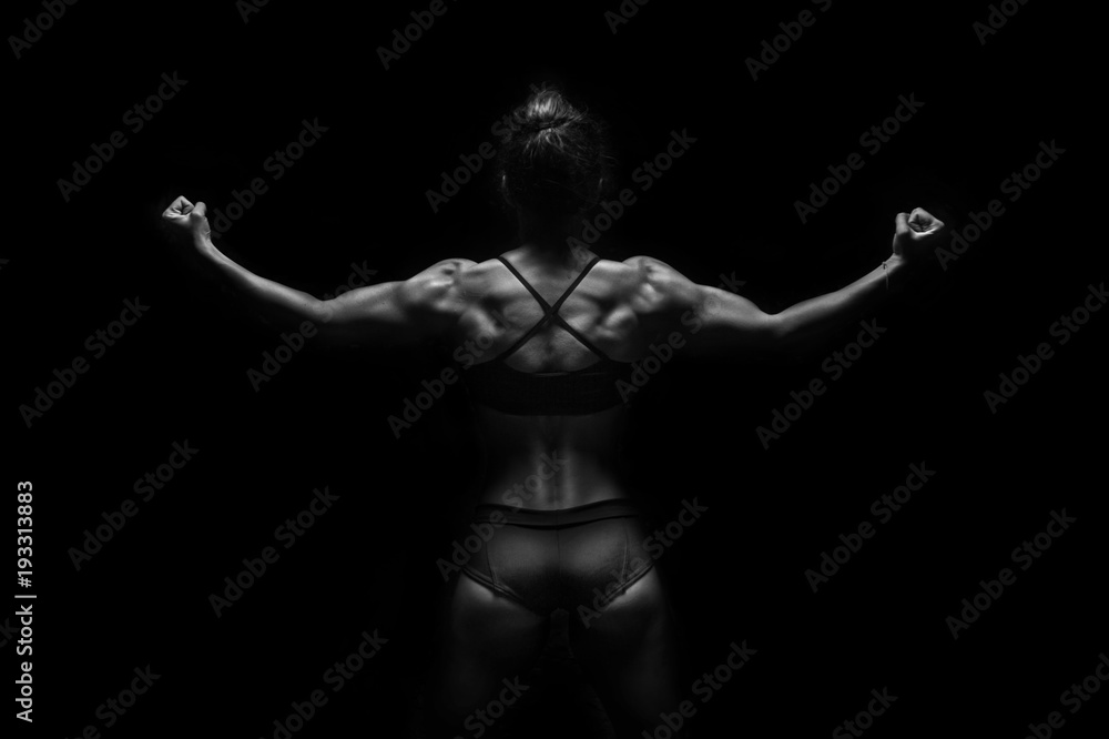 Obraz premium Fit woman demonstrate perfect back and shoulders on black background