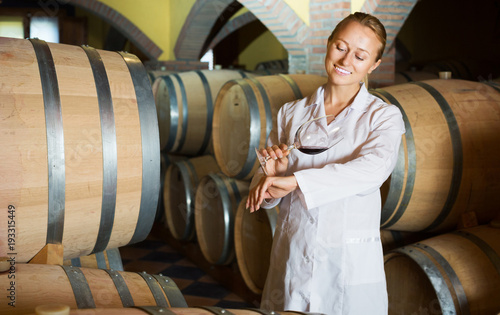 Woman checking ageing process of wine