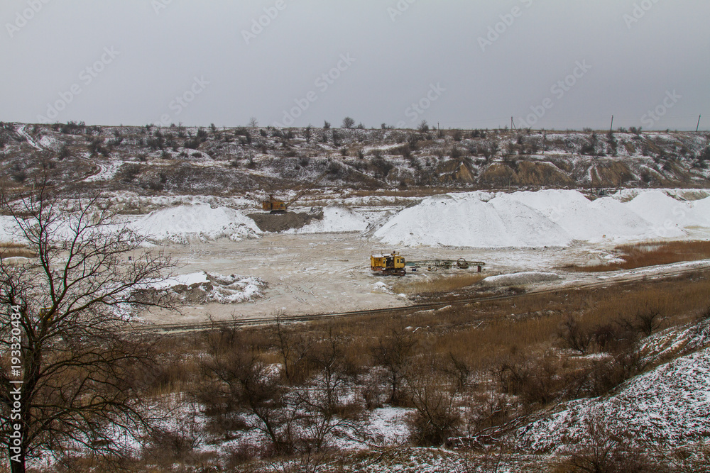 Snow-covered winter clay quarry