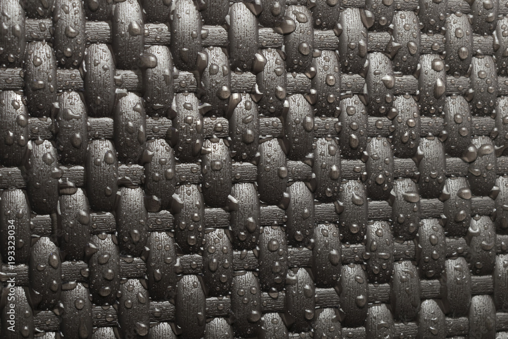 Obraz premium Drops of water on a dark background. Wicker texture