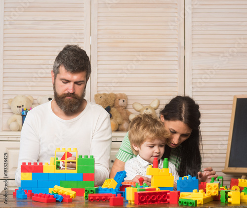Family playing with plastic blocks. Parents and kid