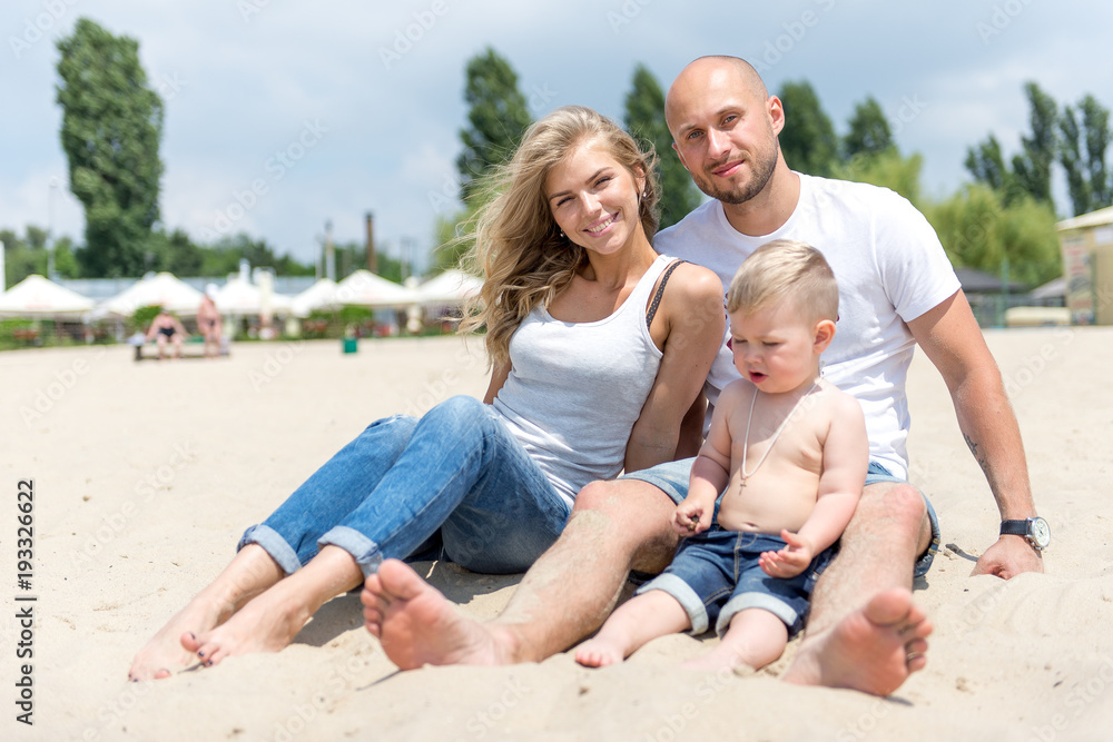 Young family with a toddler resting on the beach. Young family with a toddler resting on the beach.