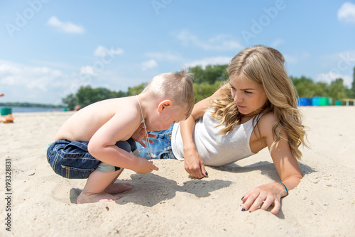 Young family with a toddler resting on the beach.