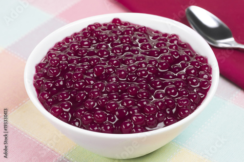Brazilian dessert called sagu in wine version in a bowl in colourful background
