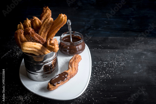 Served churros and chocolate cream on the plate,selective focus and blank space