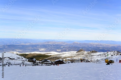 Snowy landscape of  Sierra Nevada with blue sky,  chairlift  and white mountains with snow..