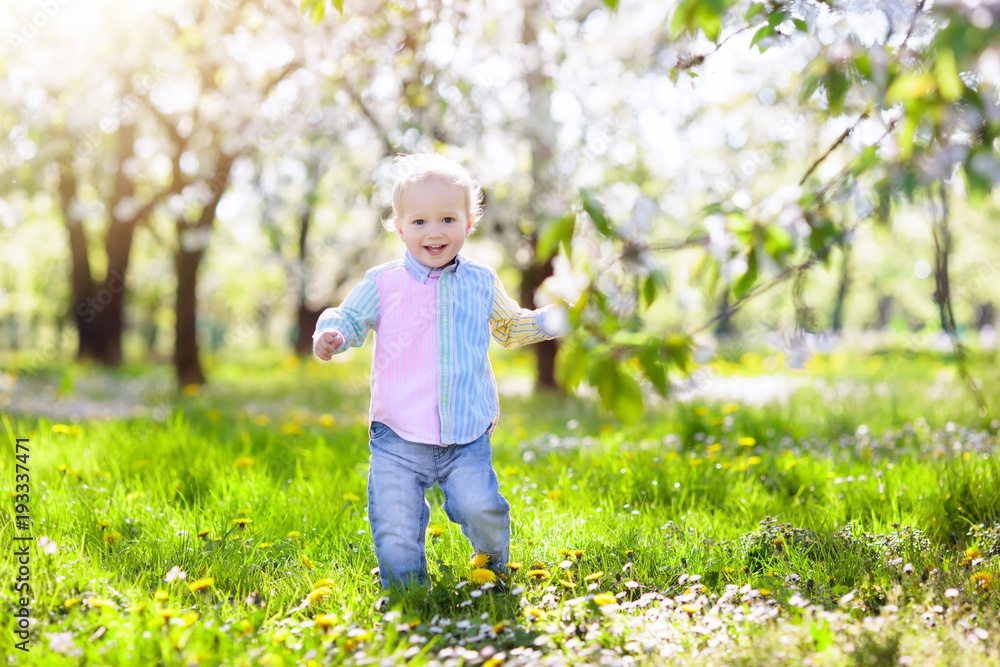 Child with cherry blossom flower. Easter egg hunt. Child with cherry blossom flower. Easter egg hunt.