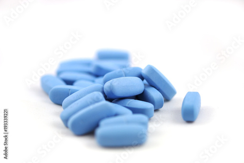 Big blue oval tablets closeup on white background