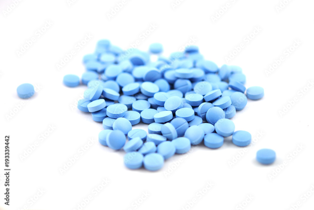 Blue round pills with natural soft shadow closeup on white background