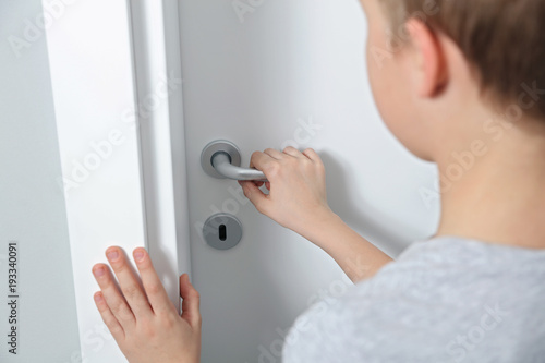Child opening door close up. Home security  safety and privacy concept