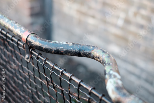 Zoomed Fencing with Old Worn Paint and Brick Backdrop
