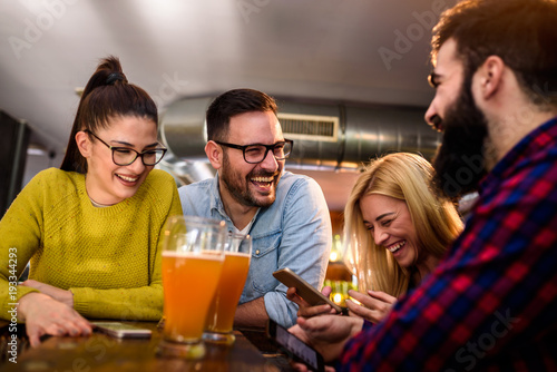 Friends in pub having fun drinking, laughing