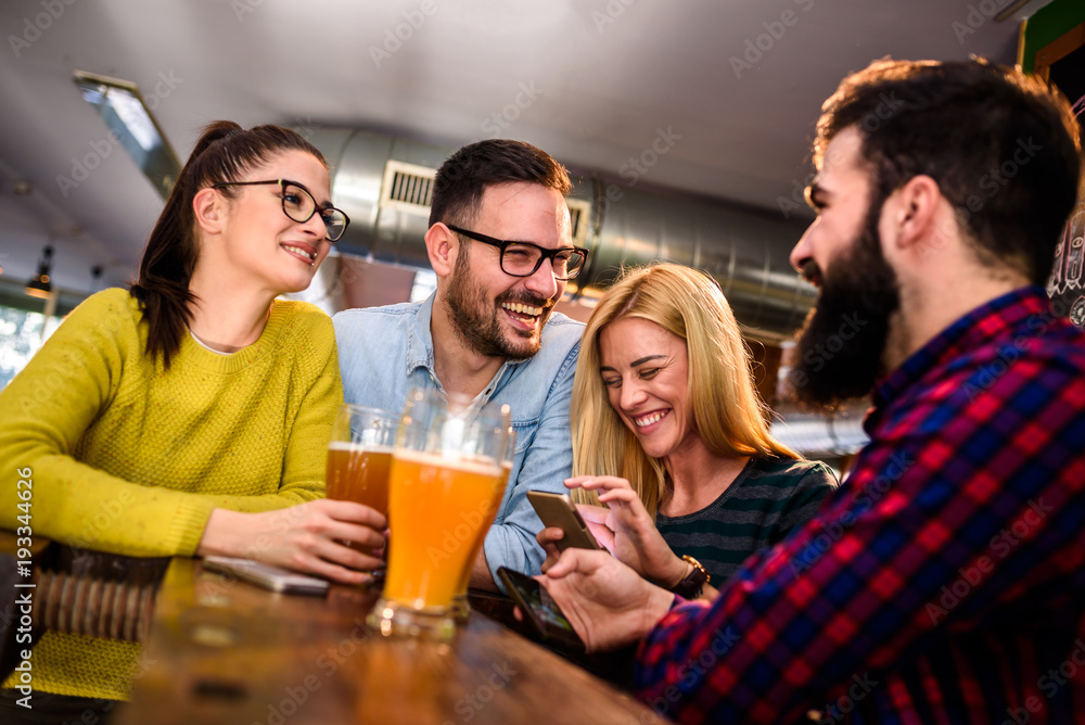 Friends in pub having fun drinking, laughing