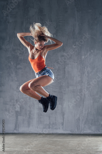 Young beautiful female dancer is posing in the studio