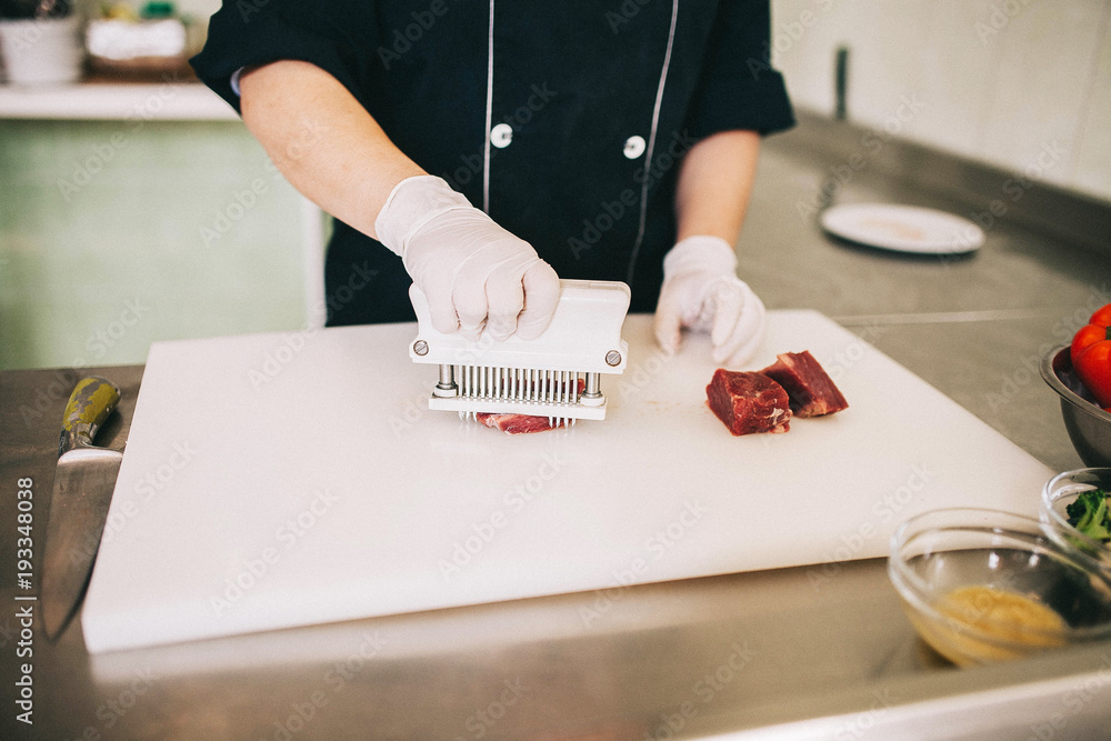 man prepares raw beef steak before cooking man prepares raw beef steak before cooking
