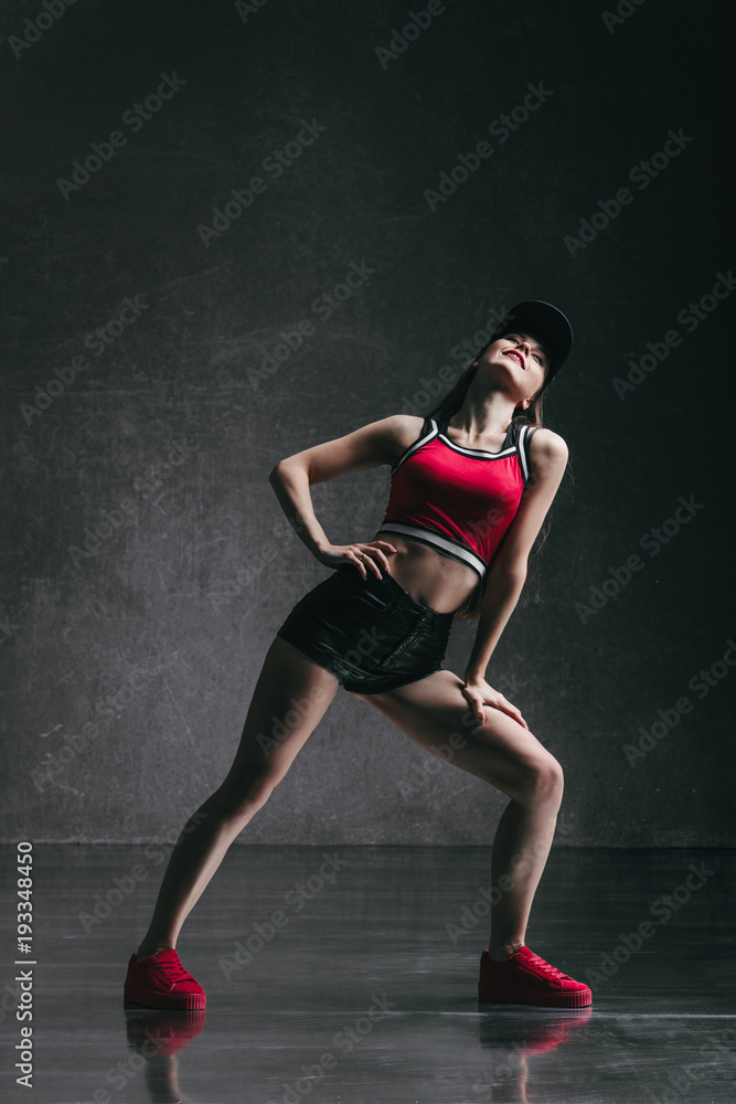 Young beautiful female dancer is posing in the studio