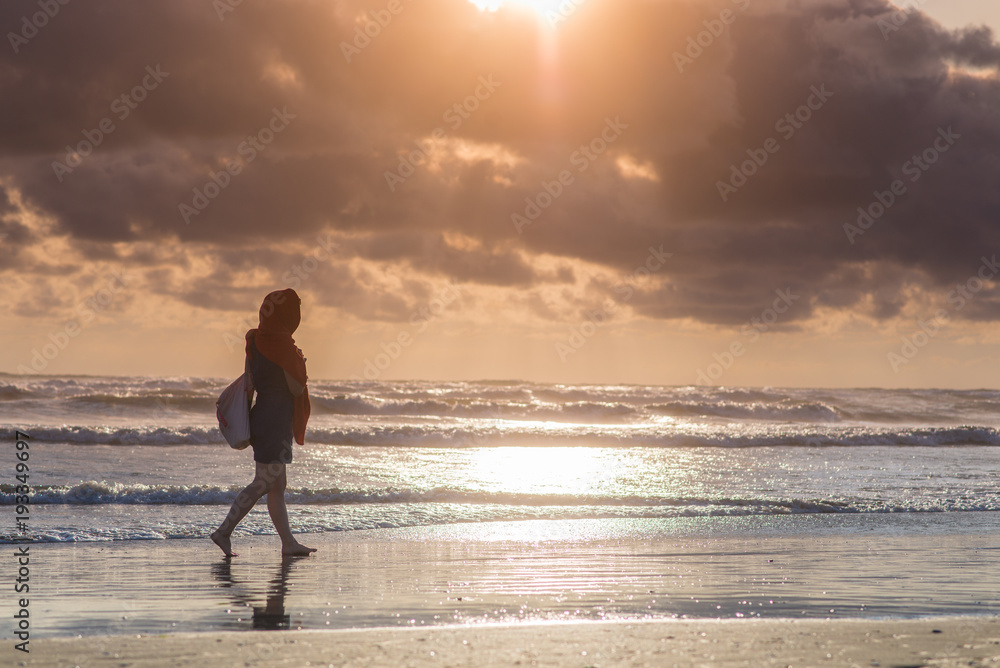 silhouette of a girl on the beach during sunset