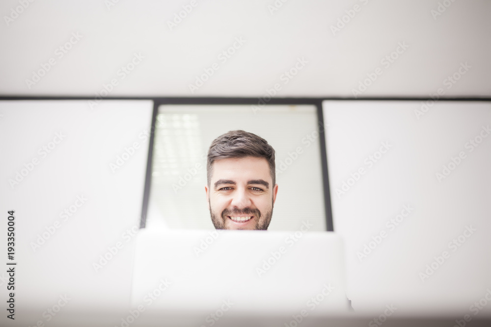 businessman in suit in meeting room with computer and window behind businessman in suit in meeting room with computer and window behind