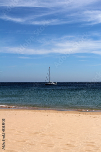 empty beach and yacht at sea