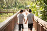 Little sibling boy walking together on the bridge