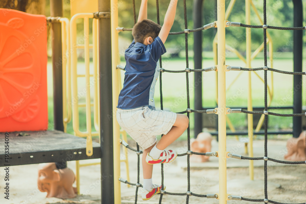 Little boy climbing up on the rope at playground Little boy climbing up on the rope at playground