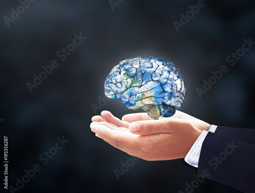 World mental health day concept. Doctor hands holding brain of earth over blurred blue nature background. Elements of this image furnished by NASA