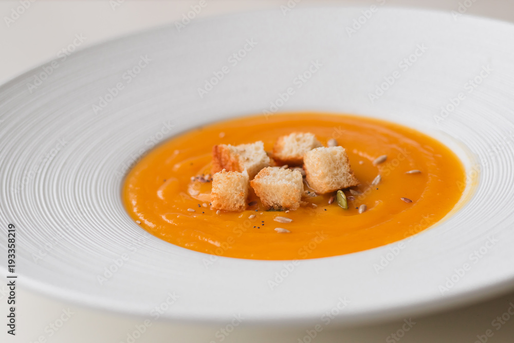Pumpkin cream soup in white plate Pumpkin cream soup in white plate