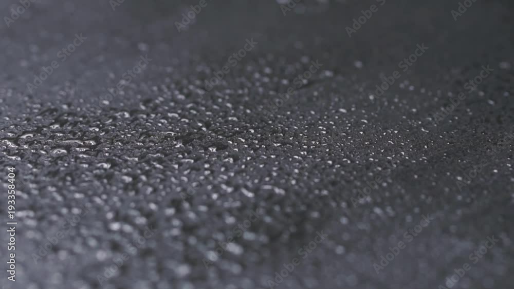 Water drops on black stone background Water drops on black stone background