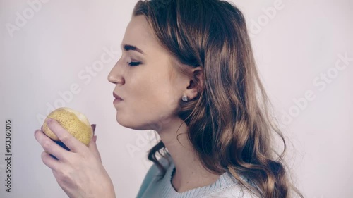Wallpaper Mural Pretty woman in a gray sweater biting a green juicy pear and chewing it. She is looking at you seductively. Locked down real time close up shot toned Torontodigital.ca