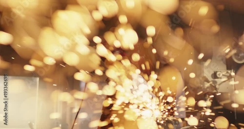 Powerful young woman using grinder and sparks flying impressivly into camera photo