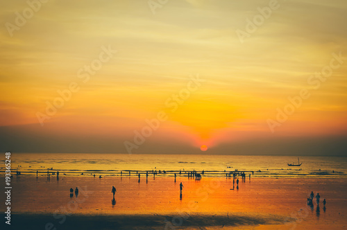 Golden sunset at sea with a lot of  traveller silhouette background