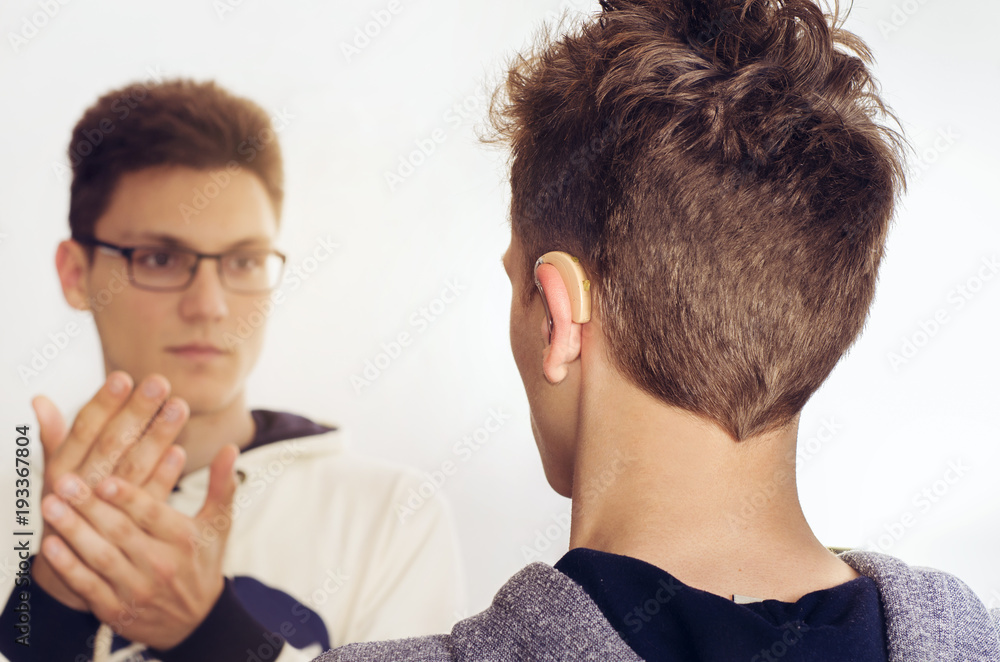 Deaf mute teenager talking with sign language, back view , focus on