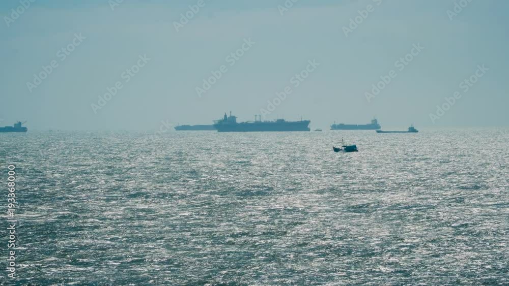 Tanker or cargo ships silhouette in the open sea at sunset Tanker or cargo ships silhouette in the open sea at sunset