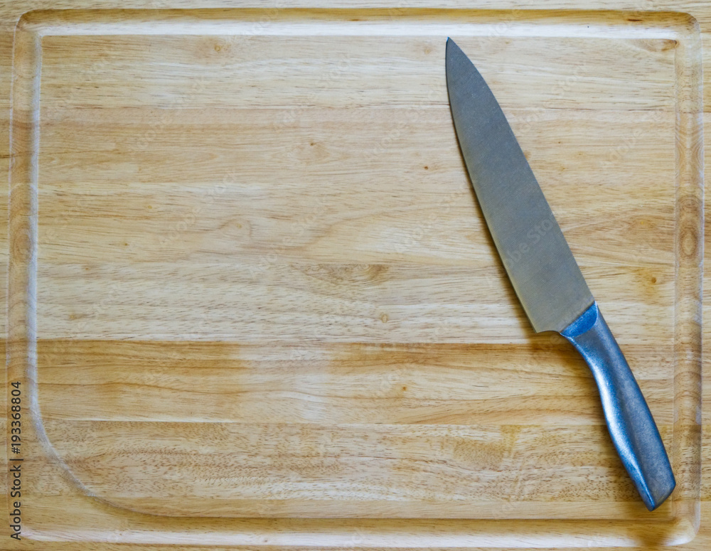 Metal knife on a wooden cutting board Metal knife on a wooden cutting board