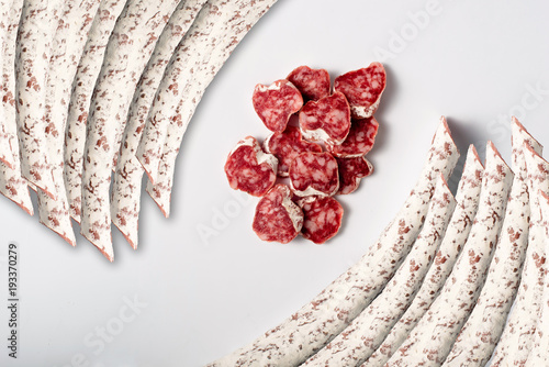 Spanish sliced moldy salami isolated on white photo