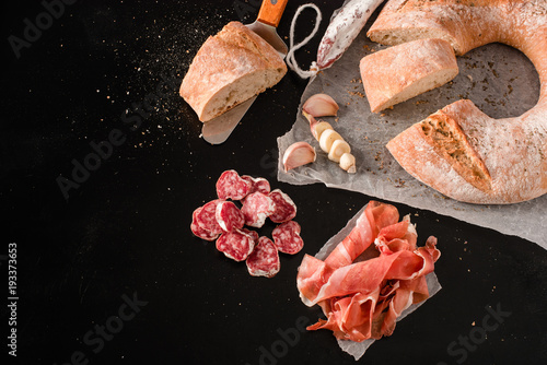Traditional Galician cut white bread with moldy salami and jamon photo