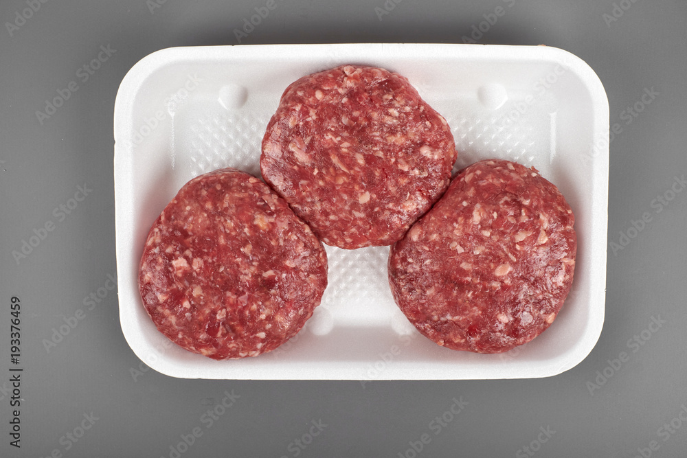 beef burgers in plastic package isolated on white background beef burgers in plastic package isolated on white background
