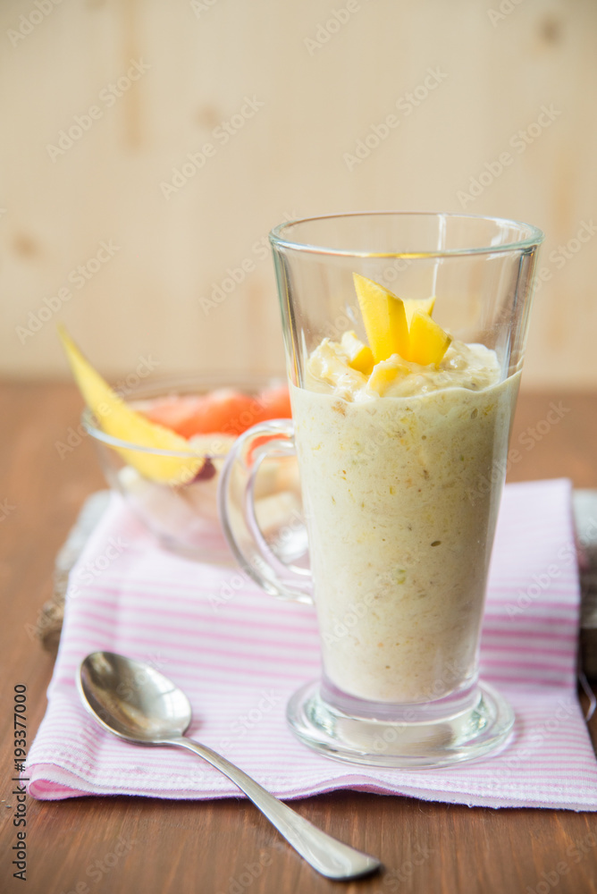 fresh smoothies in glass glass with banana, orange, mango, on wooden background. fresh smoothies in glass glass with banana, orange, mango, on wooden background.