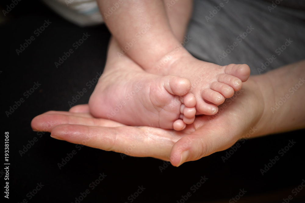 Feet of newborn baby in the hand of mother Feet of newborn baby in the hand of mother