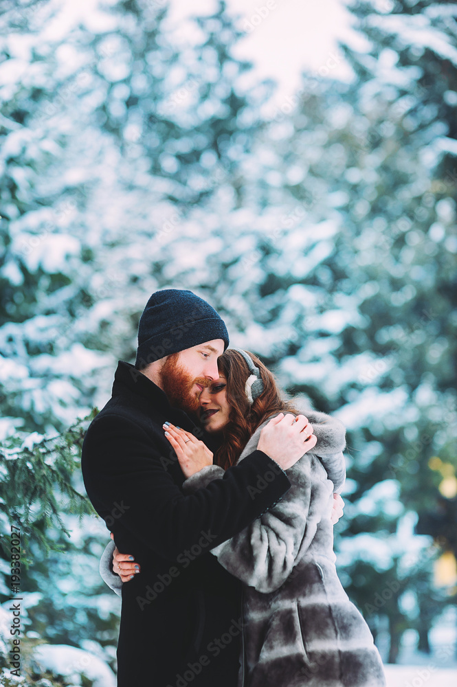 Guy and girl walk and have fun in the forest in winter