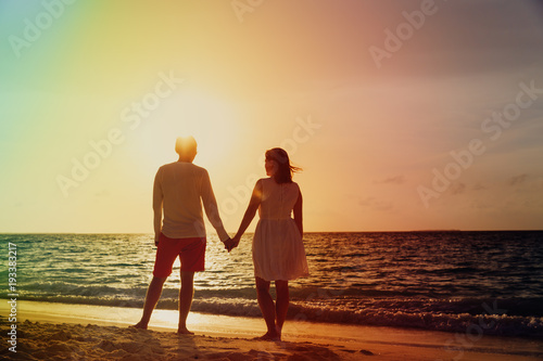 Romantic couple on tropical beach at sunset