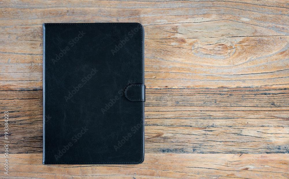 Leather case for tablet computer on wood background. Leather case for tablet computer on wood background.