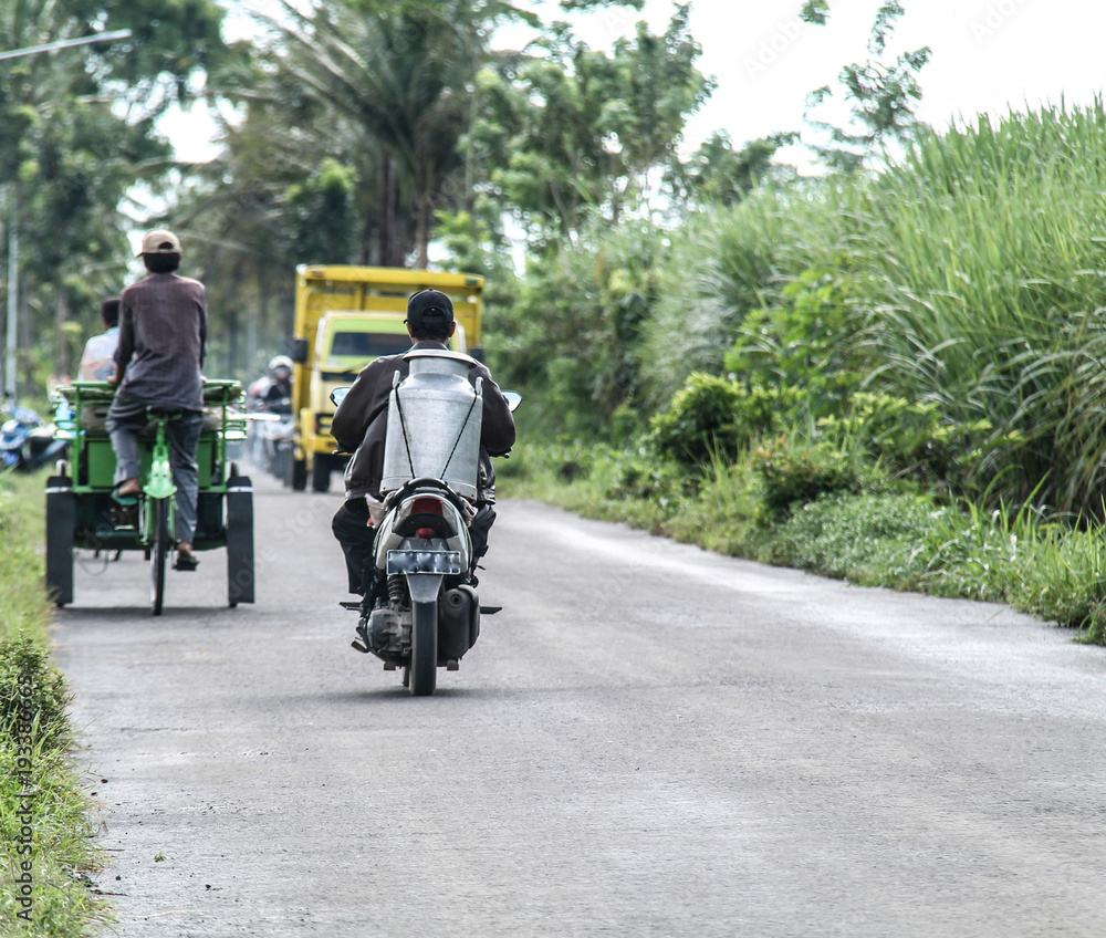 people riding motorbikes, delivering milk.