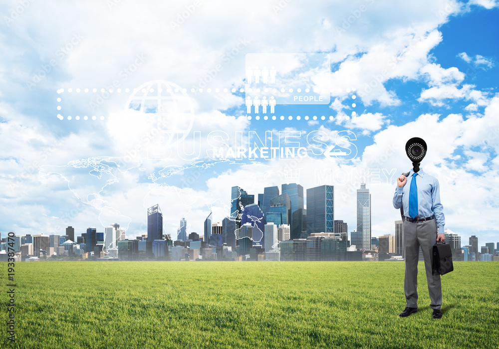Camera headed man standing on green grass against modern cityscape Camera headed man standing on green grass against modern cityscape